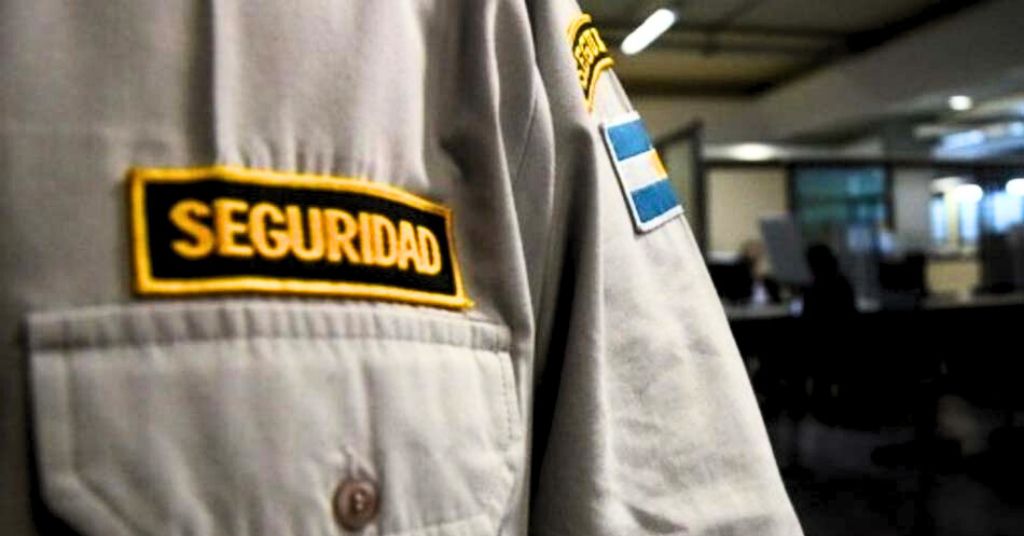 Vigilador de seguridad privada en uniforme con bandera argentina, representado por el Estudio Jurídico Abogados de los Vigiladores, expertos en derecho laboral en Buenos Aires.